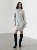 A woman wearing a mini-length grey knit Dress with a ribbed funnel neck, long sleeves and a relaxed fit.