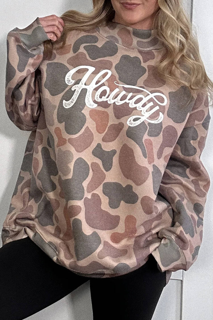 Camouflage-patterned sweatshirt with 'Howdy' text worn by a person against a white background