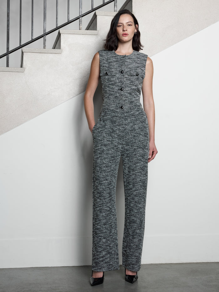 A woman wearing a black and white tweed straight leg trousers with a high waist, 2 side pockets and a full length regular fit.